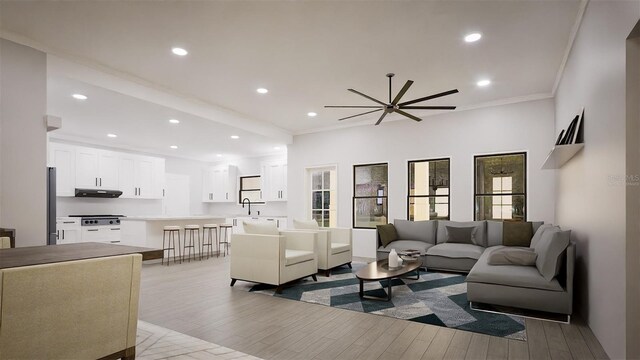 living room featuring ceiling fan, ornamental molding, sink, and light hardwood / wood-style floors