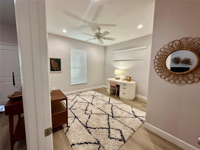 office with light hardwood / wood-style floors and ceiling fan