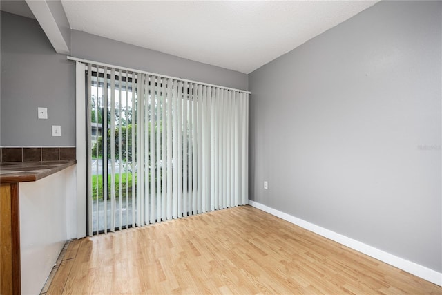 spare room with a textured ceiling and hardwood / wood-style flooring