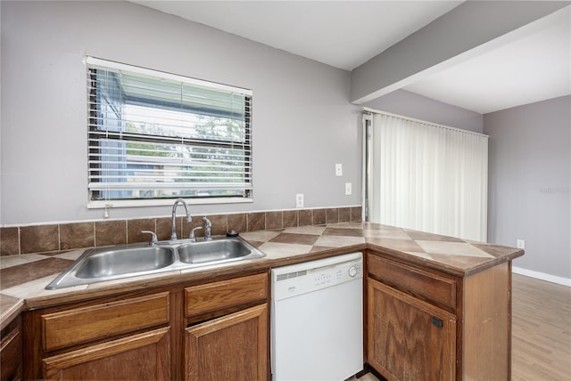 kitchen with dishwasher, light hardwood / wood-style flooring, kitchen peninsula, and sink