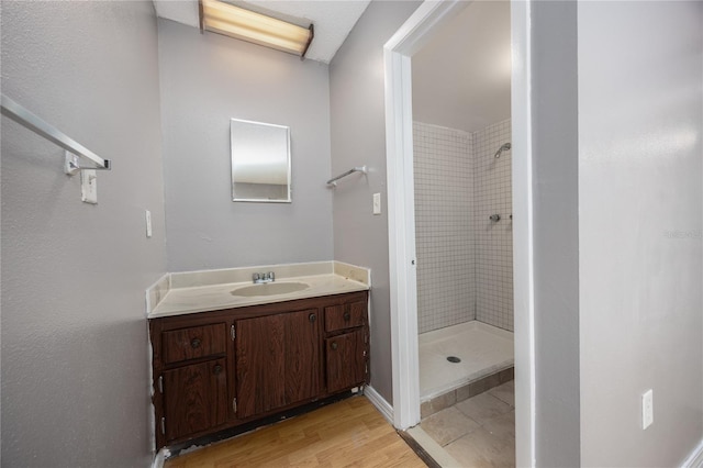 bathroom featuring vanity, a shower stall, and wood finished floors