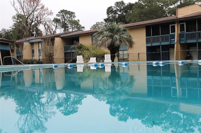 view of swimming pool featuring fence