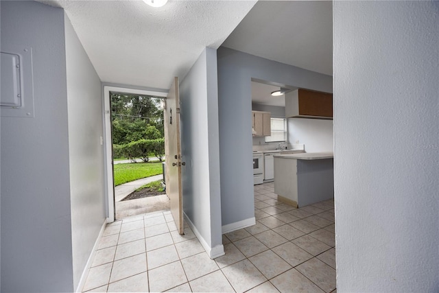 interior space with a textured ceiling and light tile patterned flooring