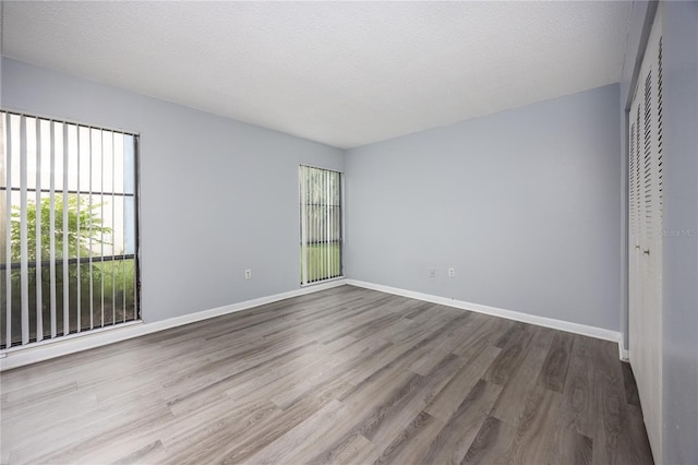 2811 SW Archer Rd Unit F47, Gainesville, FL 32608 - unfurnished room featuring wood finished floors, baseboards, and a textured ceiling