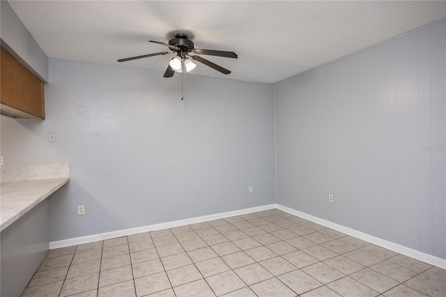 interior space with a textured ceiling, light tile patterned flooring, and ceiling fan