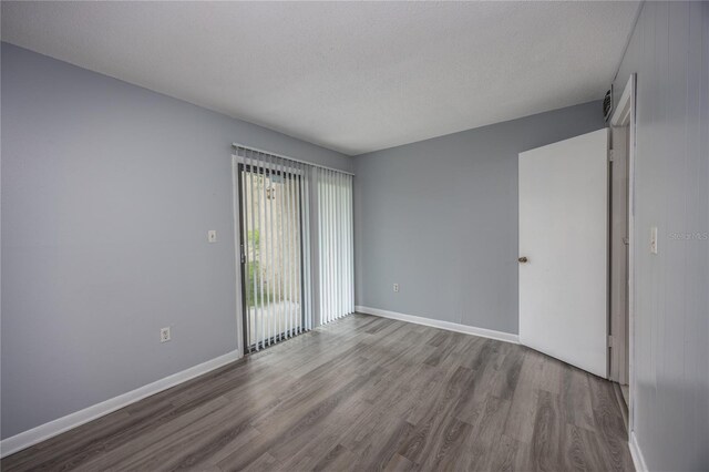 unfurnished room with a textured ceiling and hardwood / wood-style floors