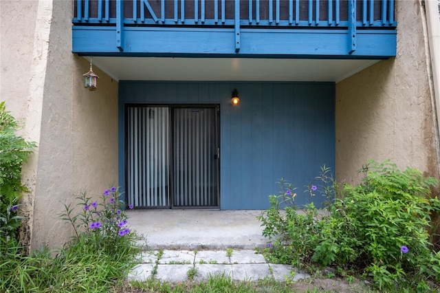 doorway to property featuring stucco siding