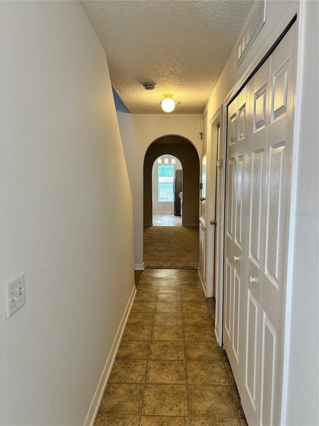 hall with a textured ceiling