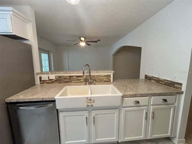 kitchen featuring tasteful backsplash, kitchen peninsula, stainless steel dishwasher, and ceiling fan