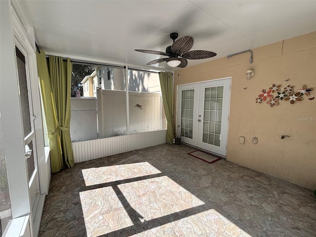 unfurnished sunroom with ceiling fan and french doors