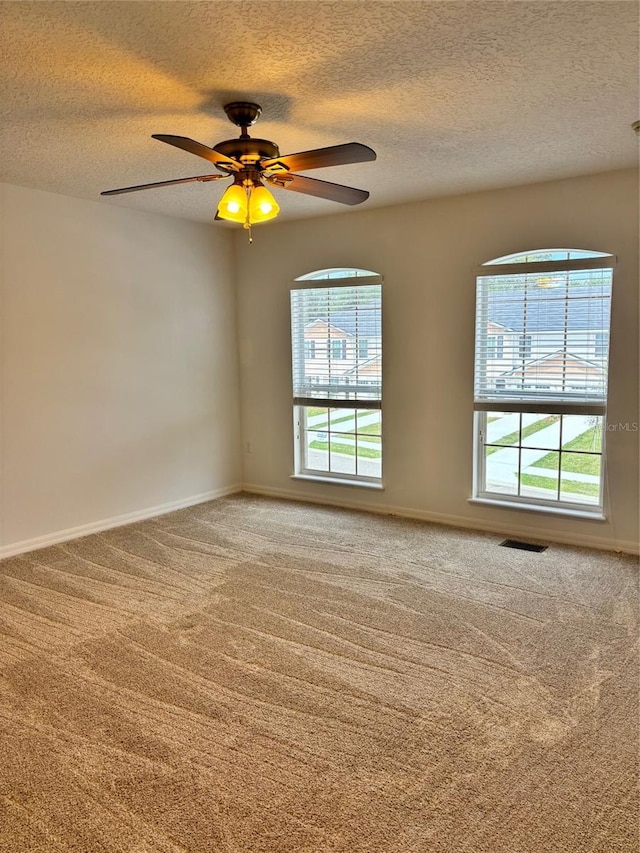 carpeted empty room with a textured ceiling and ceiling fan