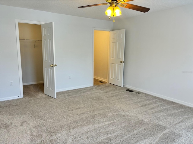 unfurnished bedroom with a textured ceiling, ceiling fan, and light carpet