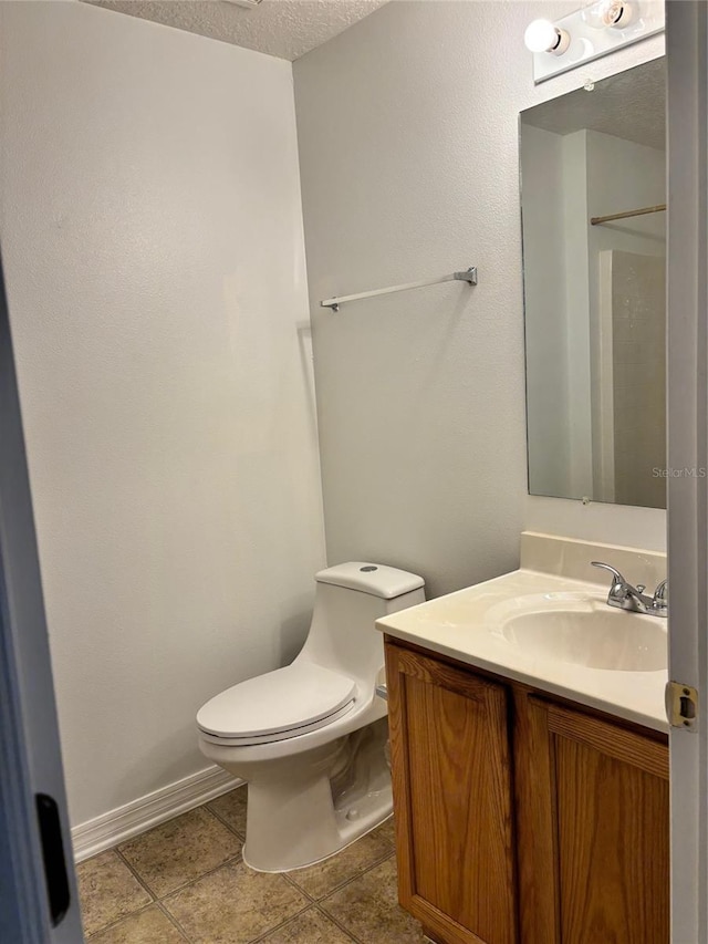 bathroom featuring a textured ceiling, vanity, toilet, and tile patterned flooring