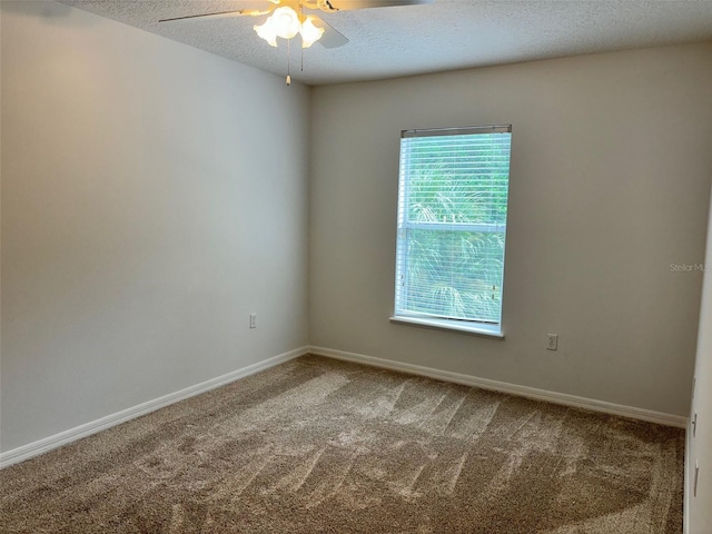 carpeted spare room featuring ceiling fan, a textured ceiling, and a healthy amount of sunlight