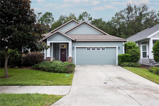 craftsman house featuring a garage and a front lawn