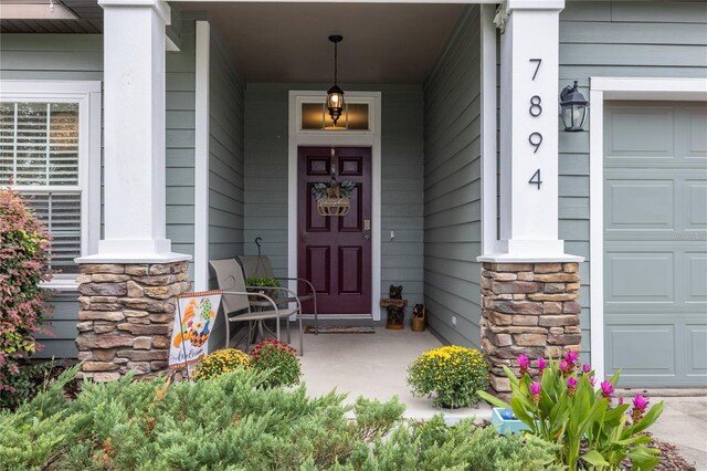 doorway to property featuring a garage and a porch