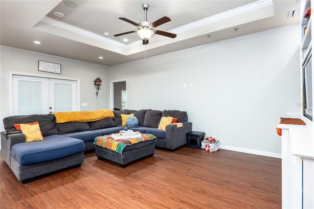 living room with crown molding, a raised ceiling, ceiling fan, and hardwood / wood-style floors