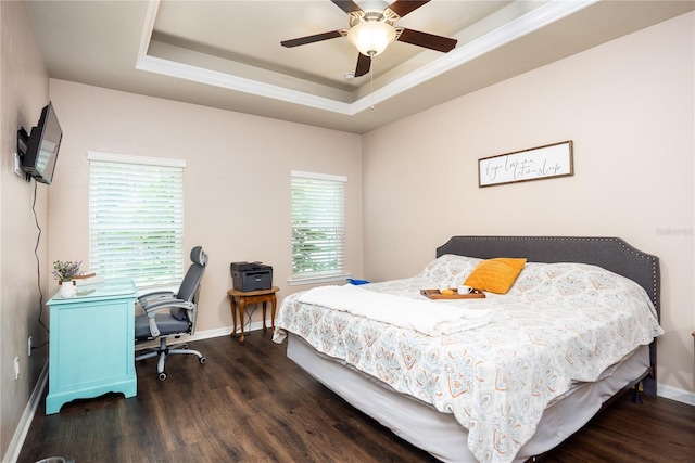 bedroom featuring dark wood-type flooring, a tray ceiling, and ceiling fan