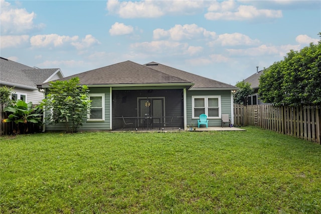 rear view of property with a yard, a patio, and a sunroom