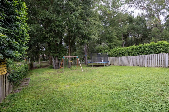 view of yard featuring a playground and a trampoline