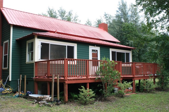 rear view of house with a deck and a lawn