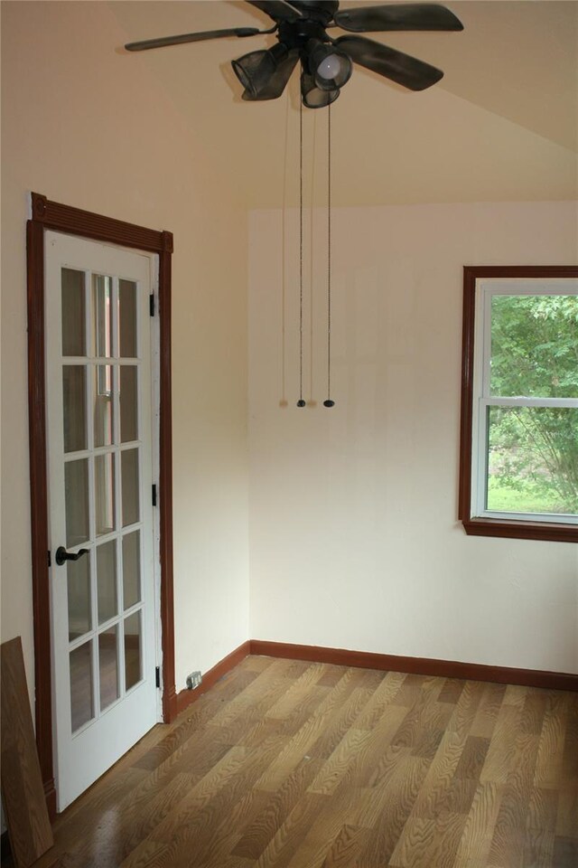 empty room featuring ceiling fan, hardwood / wood-style floors, and vaulted ceiling