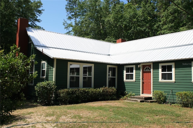 21317 SE 111th Ave, Hawthorne, FL 32640 - view of front facade with a chimney, a front yard, and metal roof