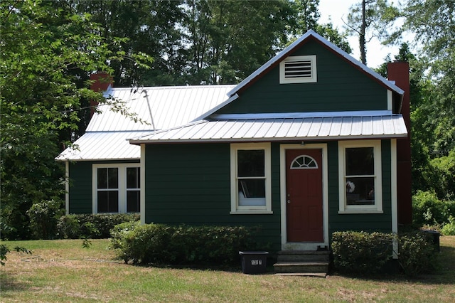 21317 SE 111th Ave, Hawthorne, FL 32640 - bungalow with a chimney, entry steps, a front lawn, and metal roof