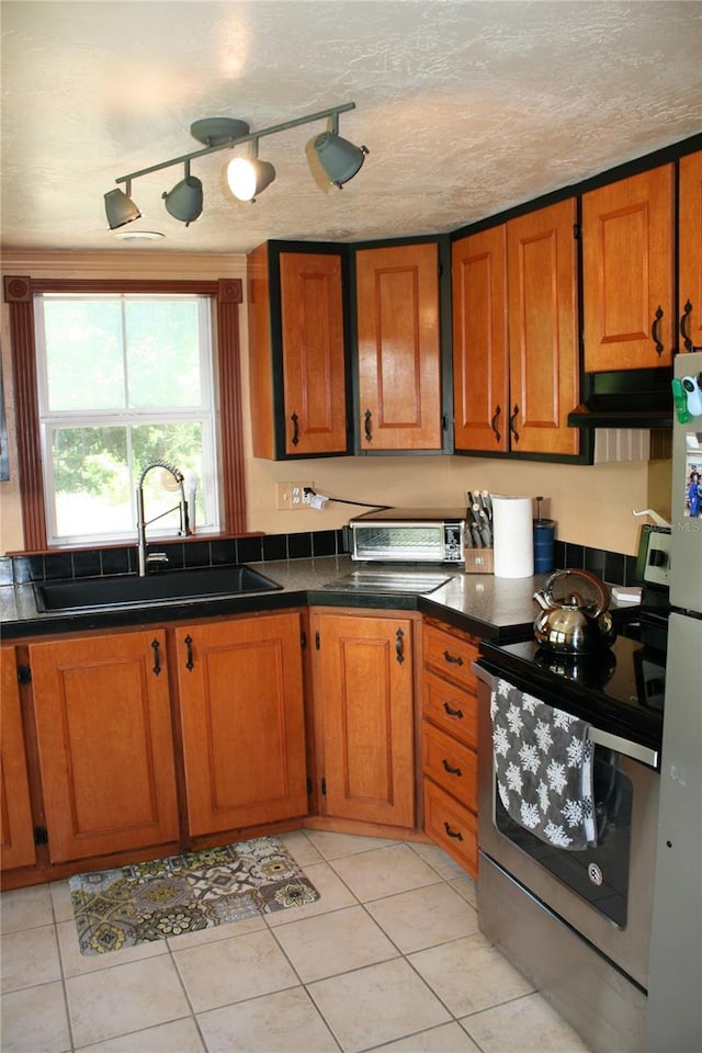 21317 SE 111th Ave, Hawthorne, FL 32640 - kitchen featuring a sink, stainless steel range with electric stovetop, brown cabinets, under cabinet range hood, and dark countertops