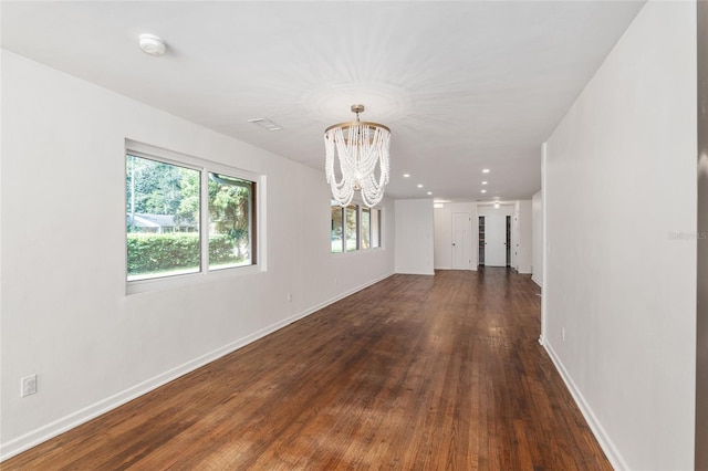 unfurnished room with dark hardwood / wood-style flooring and a notable chandelier