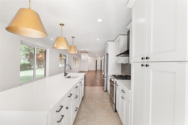 kitchen with sink, stainless steel appliances, tasteful backsplash, decorative light fixtures, and a center island with sink