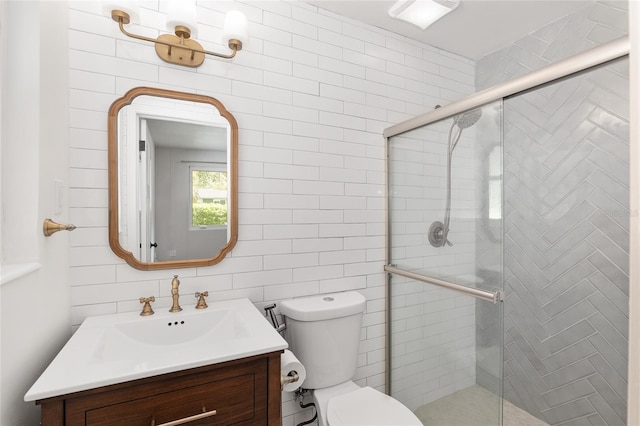 bathroom with vanity, toilet, walk in shower, and tile walls