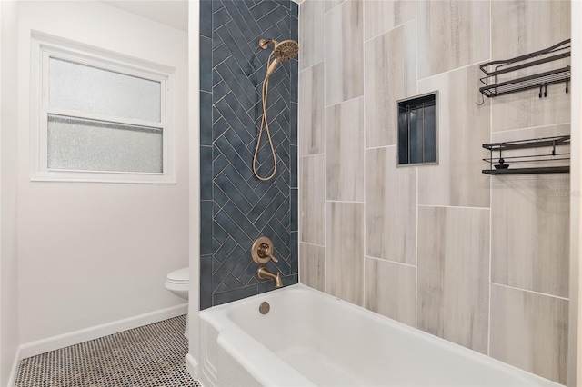 bathroom featuring tile patterned floors, toilet, and tiled shower / bath