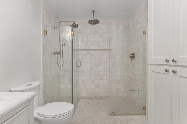 bathroom with vanity, toilet, and a shower with shower door