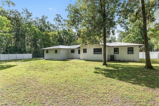 back of house featuring a lawn and central AC