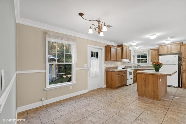 kitchen featuring white appliances, a center island, decorative light fixtures, ornamental molding, and a chandelier