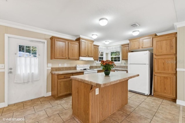 kitchen with a center island, white appliances, crown molding, light tile patterned floors, and a breakfast bar