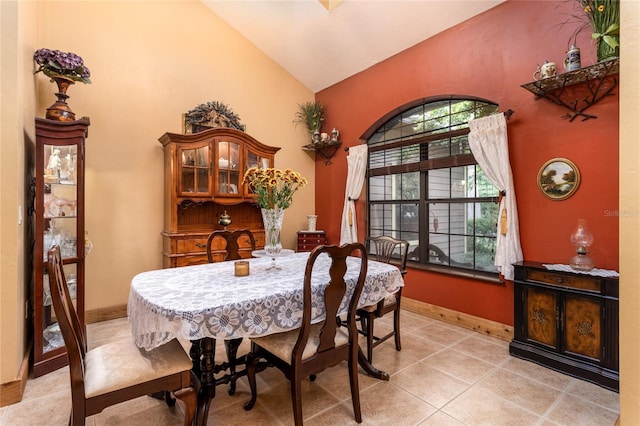 dining space featuring lofted ceiling and light tile patterned flooring