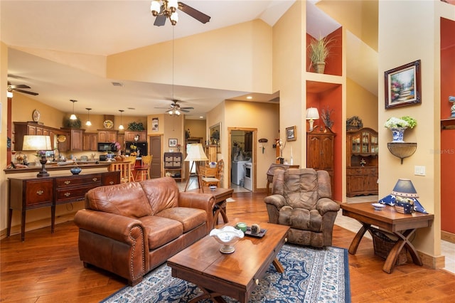 living room featuring hardwood / wood-style floors, high vaulted ceiling, and ceiling fan