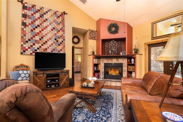 living room with a tiled fireplace, wood-type flooring, and lofted ceiling