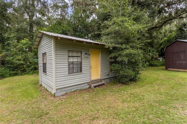 view of outbuilding featuring a lawn