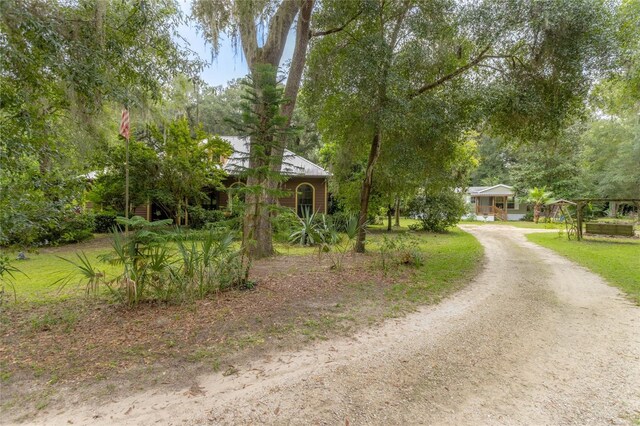 view of property hidden behind natural elements with a front yard