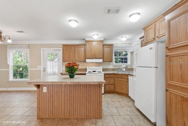 kitchen featuring a kitchen island, hanging light fixtures, ornamental molding, light tile patterned floors, and white appliances