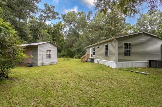 view of yard featuring a shed and central AC unit