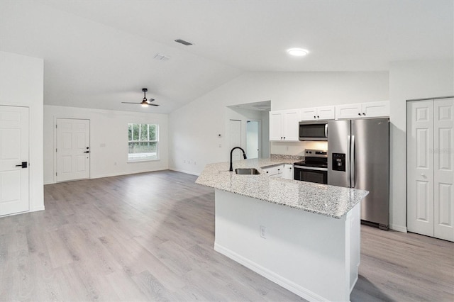 kitchen featuring sink, light hardwood / wood-style flooring, vaulted ceiling, white cabinetry, and stainless steel appliances