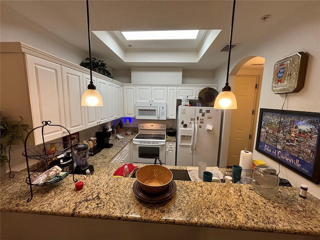 kitchen featuring decorative light fixtures, a raised ceiling, white appliances, and white cabinetry