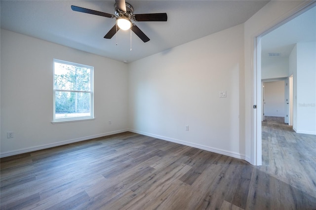 spare room featuring hardwood / wood-style floors and ceiling fan