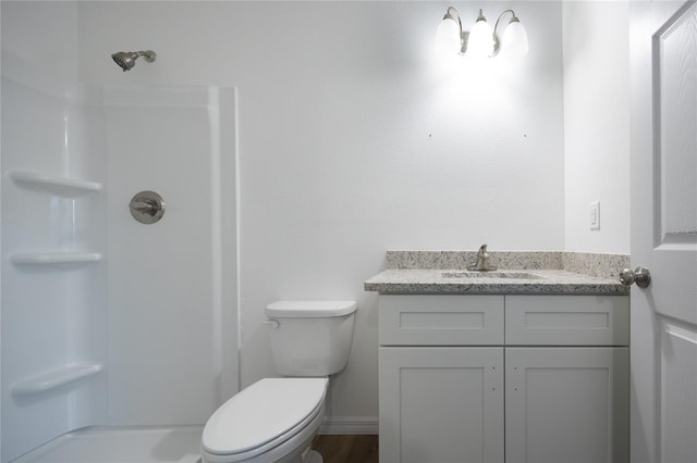 bathroom featuring vanity, toilet, and a shower