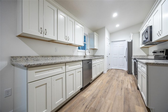 kitchen with appliances with stainless steel finishes, light stone countertops, and white cabinets