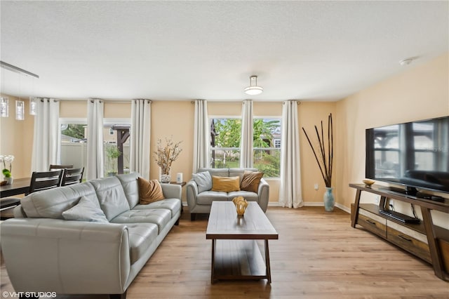 living room featuring a textured ceiling and light hardwood / wood-style floors